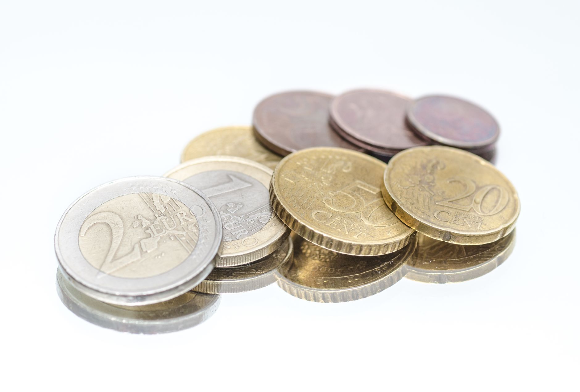 EuromĂŒnzen verschiedener Werte, gestapelt auf einer hellen FlĂ€che