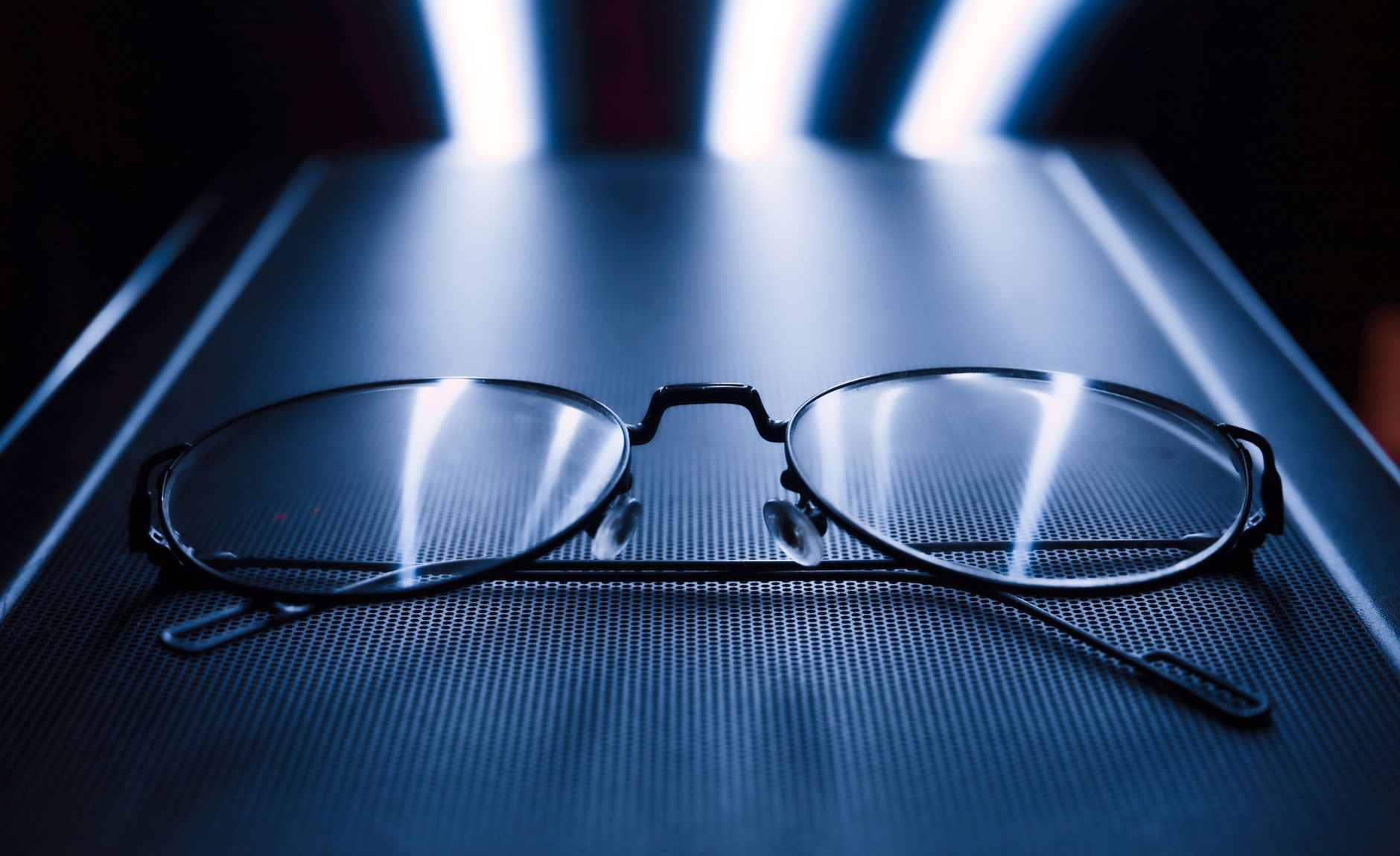 Glasses on a laptop in the blue light of the screen