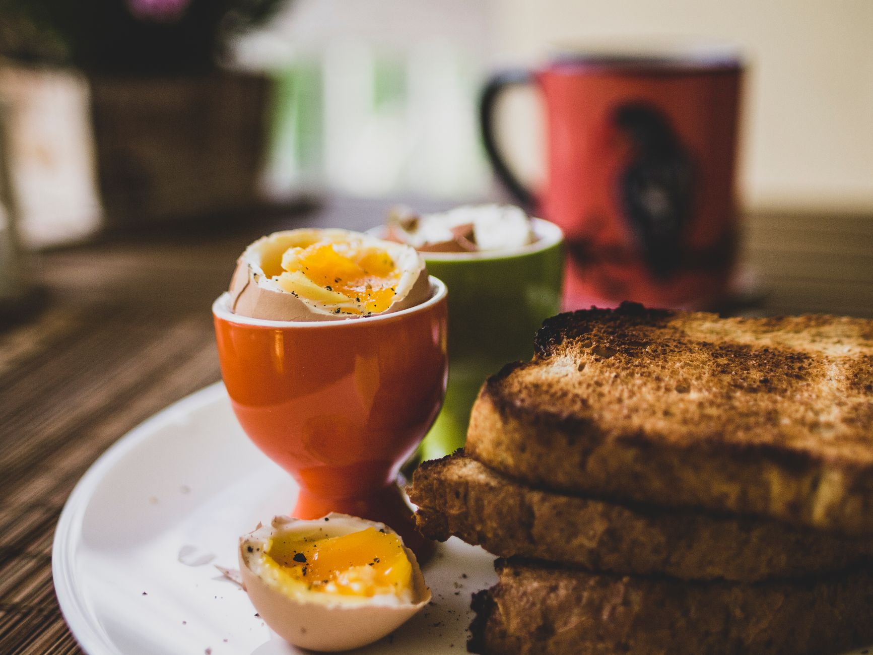 Weichgekochte Eier mit Toast auf einem Frühstückstisch