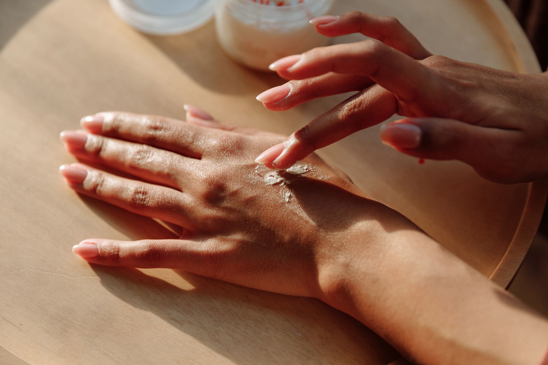 Hände beim Eincremen mit einer Handcreme