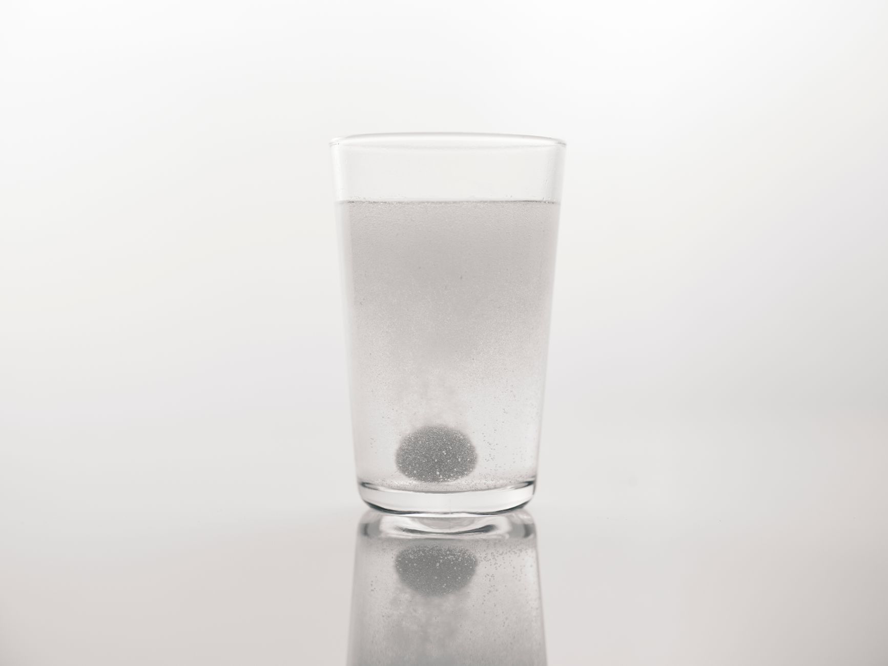 Brausetablette löst sich in einem Glas Wasser auf