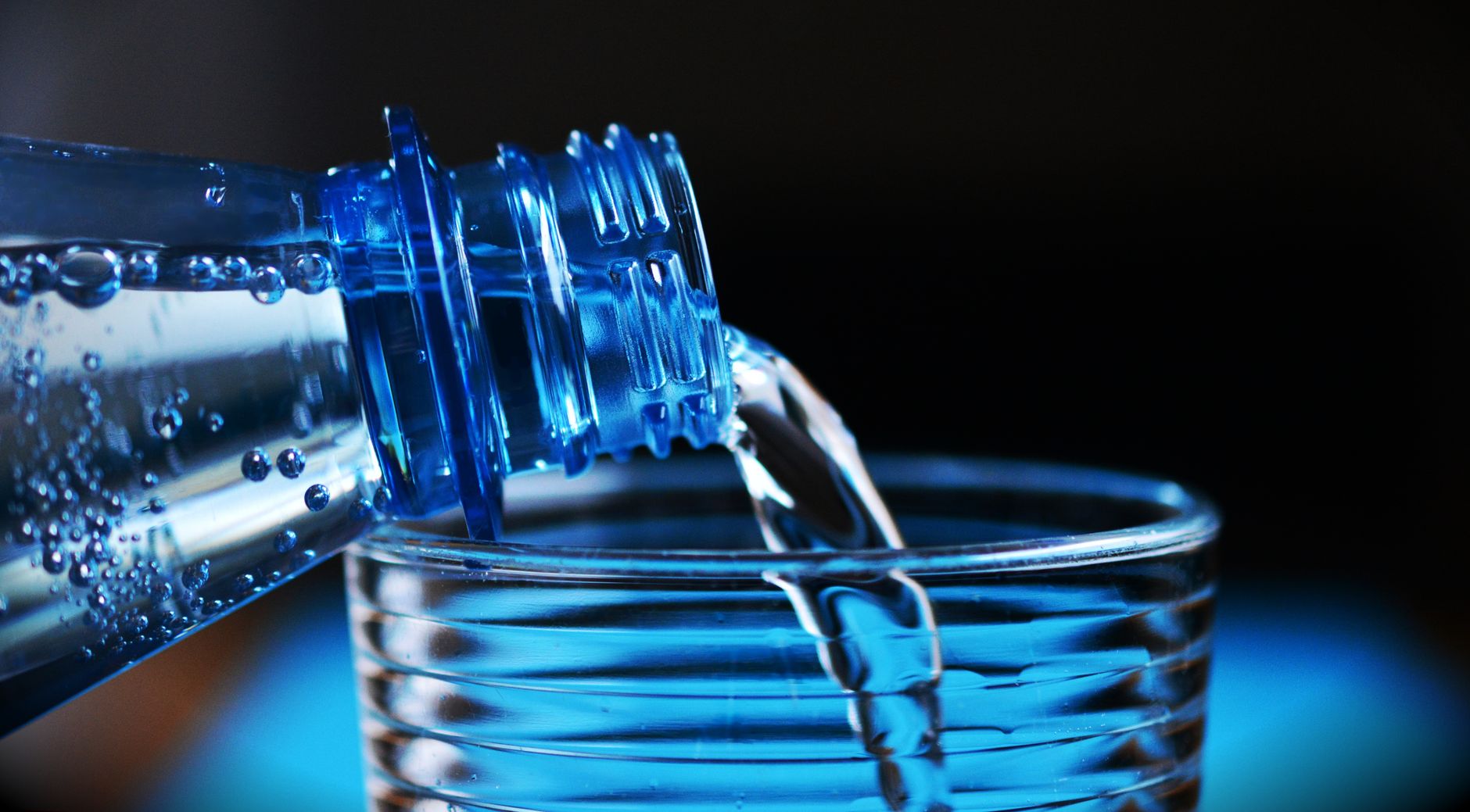 Mineralwasser wird aus einer Flasche in ein Glas gegossen