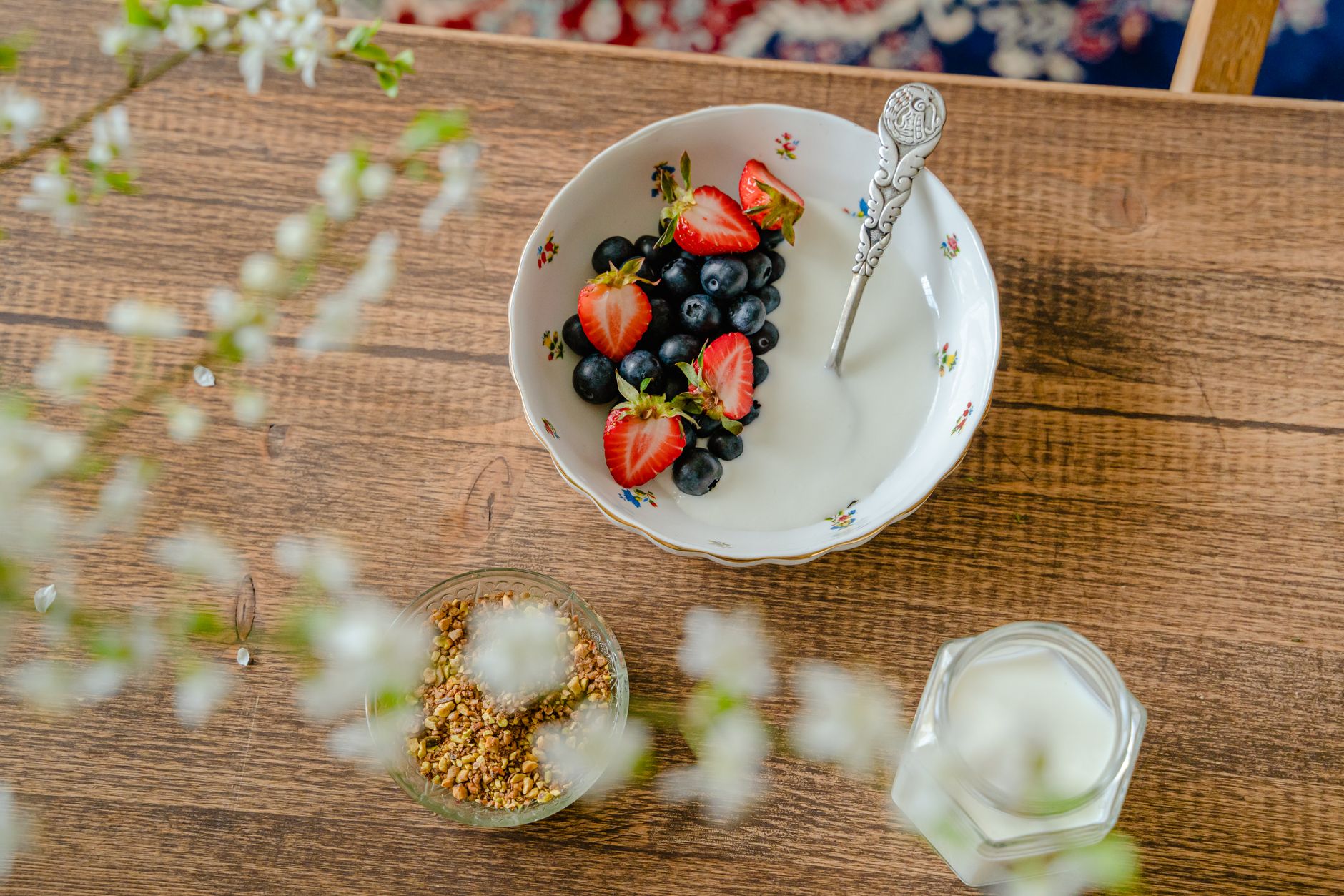 Schale mit Joghurt, Beeren und Müsli auf einem Holztisch