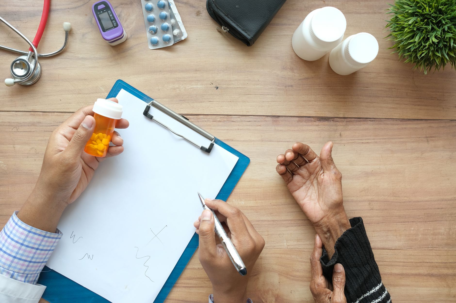 Ärztin mit Tablettendose und Klemmbrett im Gespräch mit einer Patientin