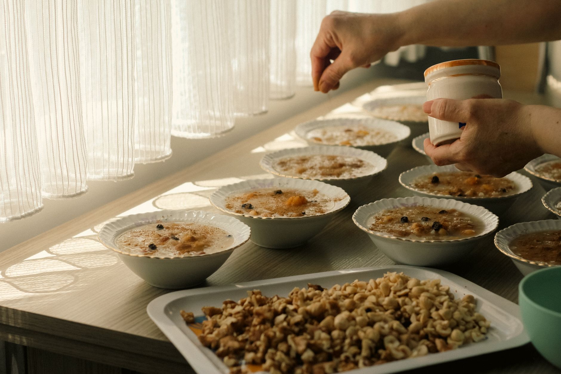 Due ciotole di fiocchi d'avena con noci e frutta su un tavolo soleggiato