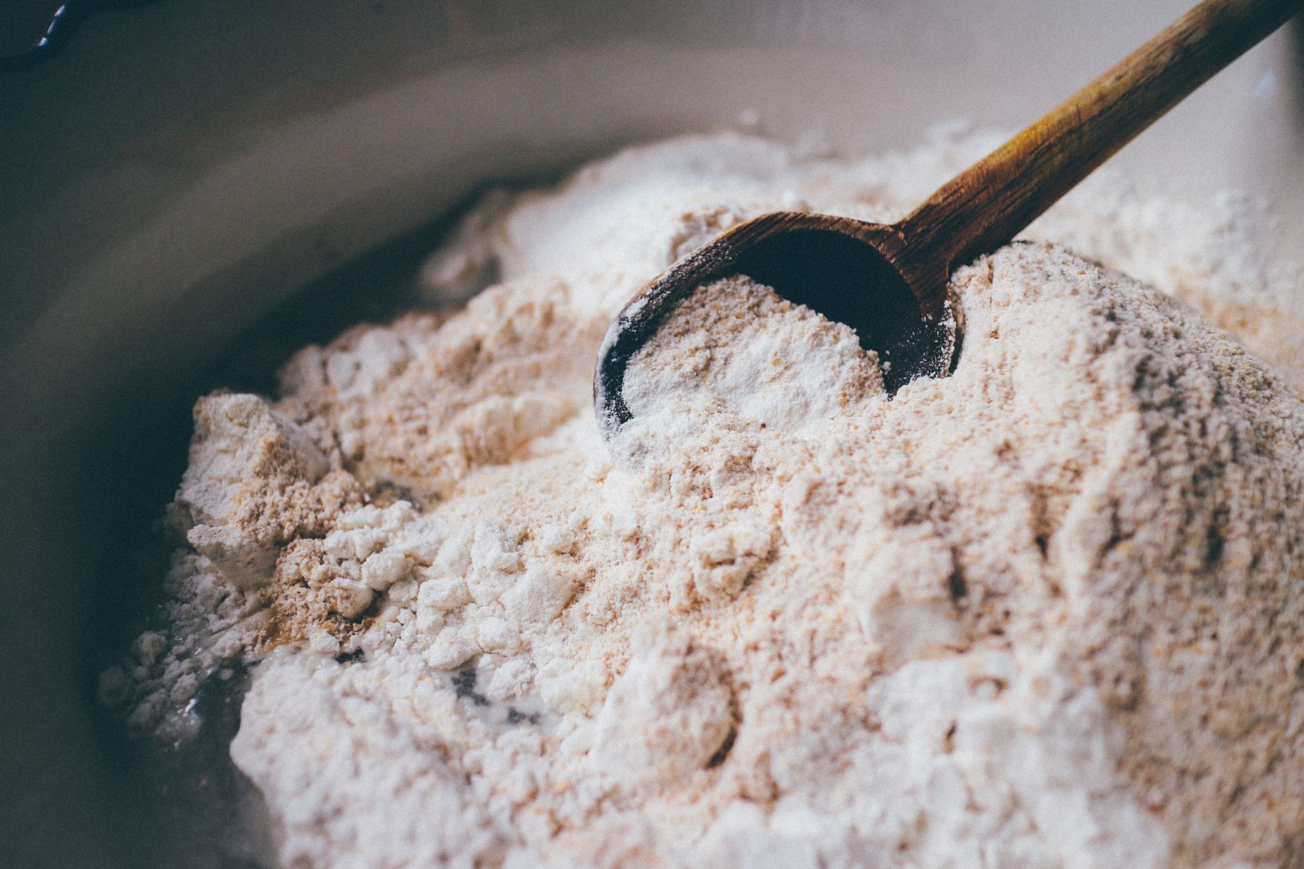 Weizenmehl mit einem Holzlöffel — Weizen ist die größte Fructanquelle der Alltagskost