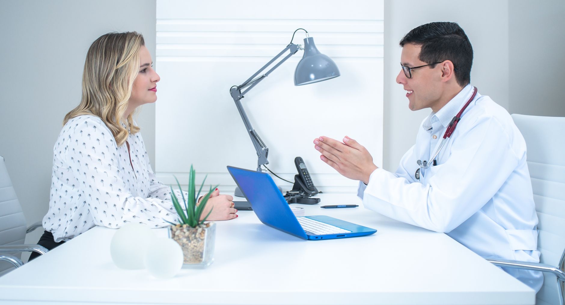 Ärztin im Gespräch mit einem Patienten am Schreibtisch