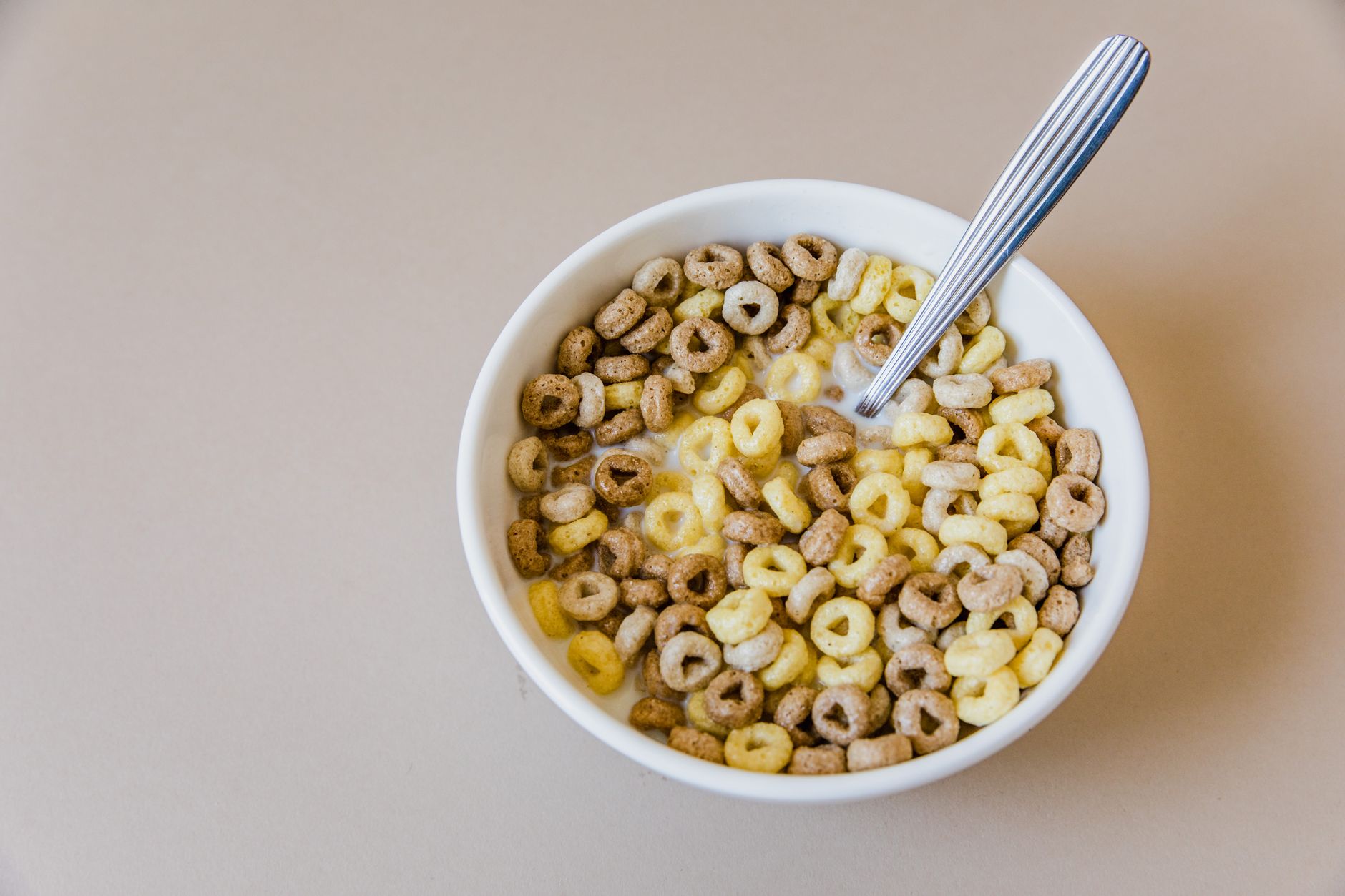 Schale mit Frühstückszerealien und Milch, Löffel darin