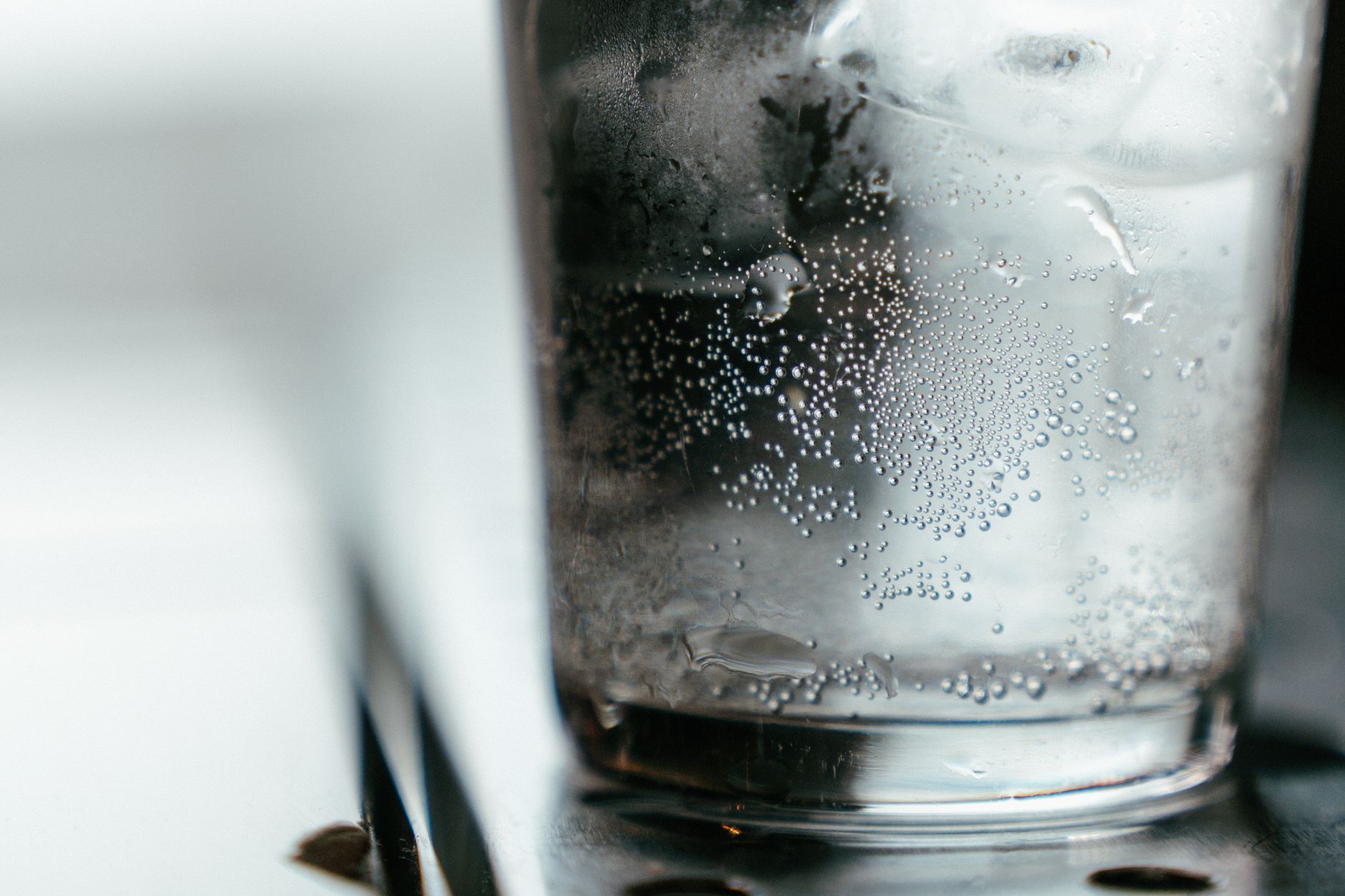 Glas mit Mineralwasser und aufsteigenden Bläschen