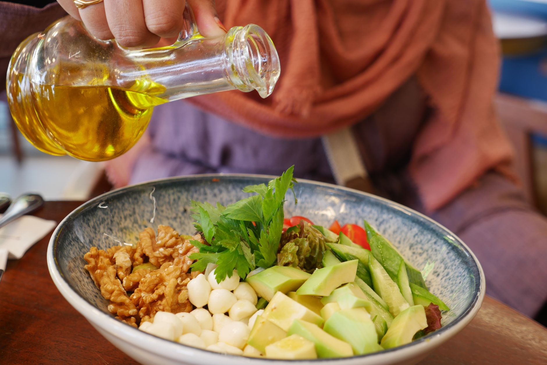 Öl wird über einen Salat gegossen
