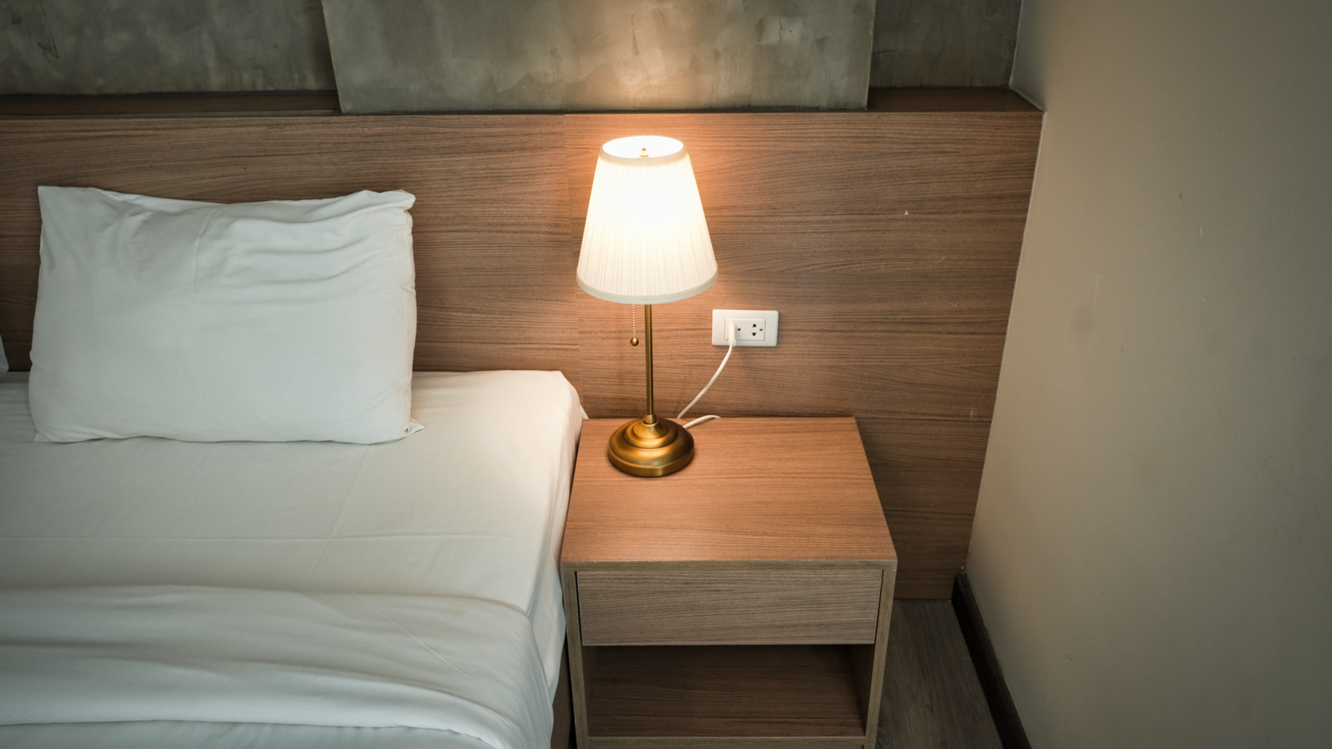 Nachttischlampe neben einem gemachten Bett