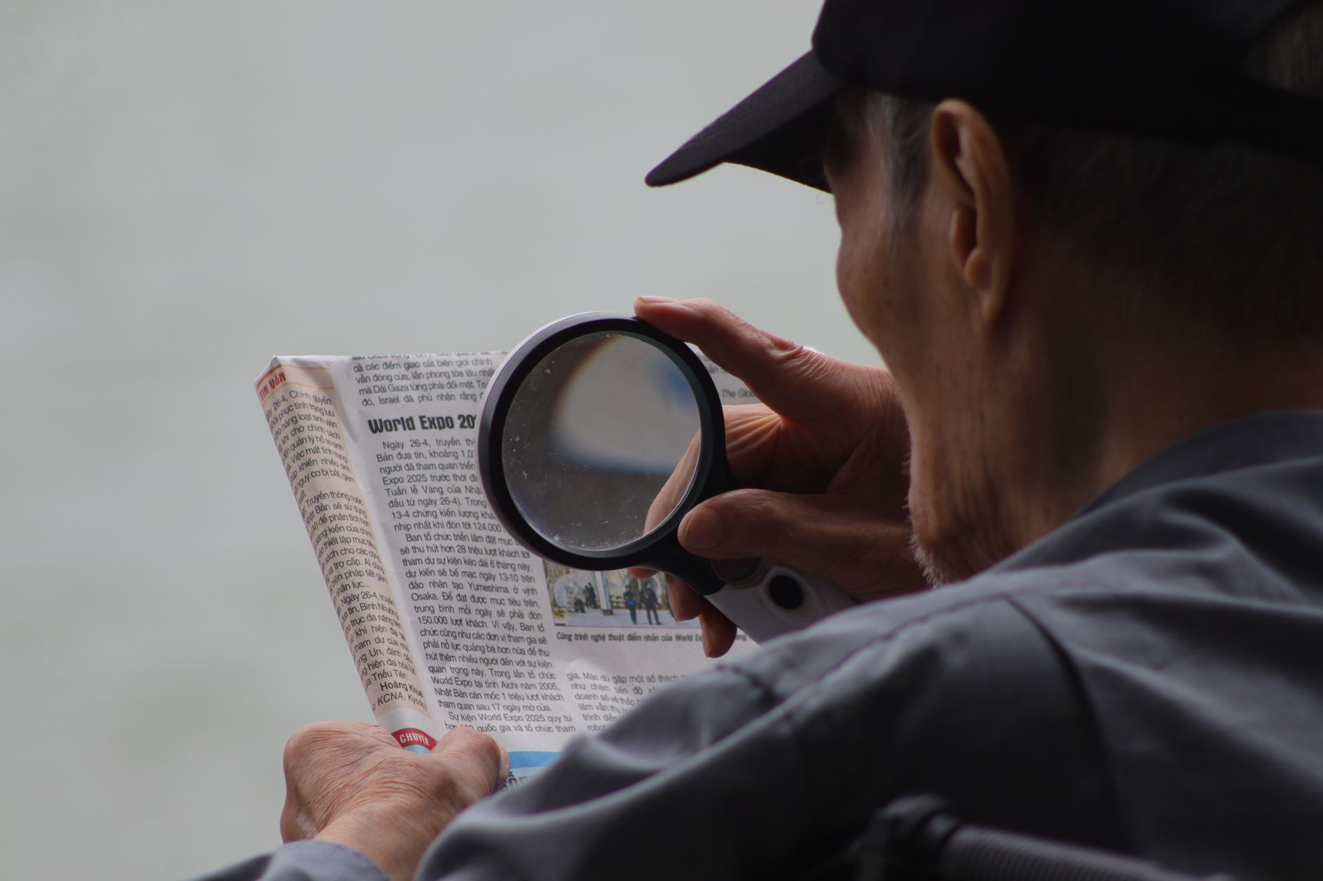 An older person reading the small print with a magnifying glass