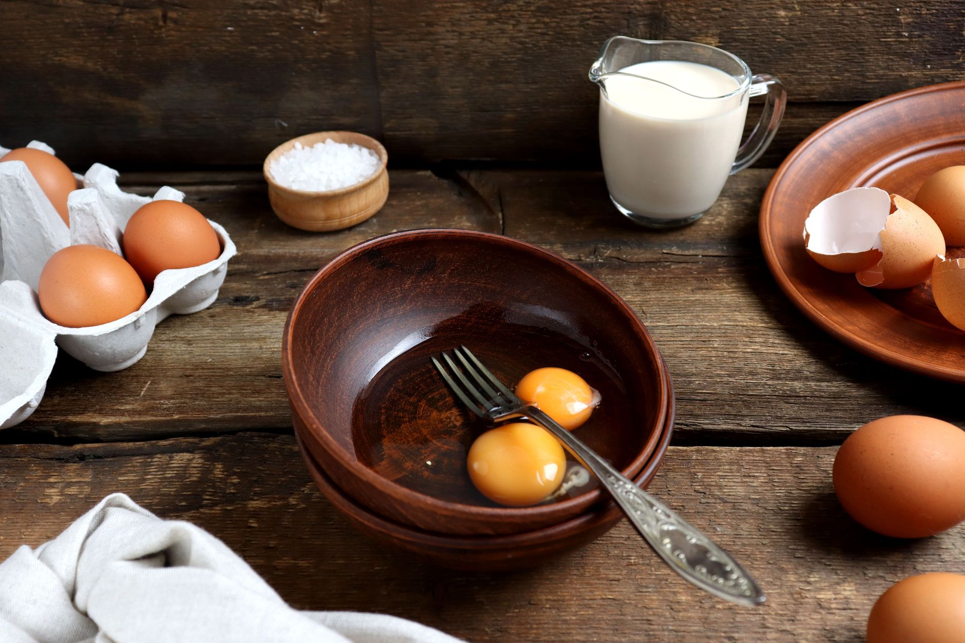 Œufs, lait et sel sur une table en bois