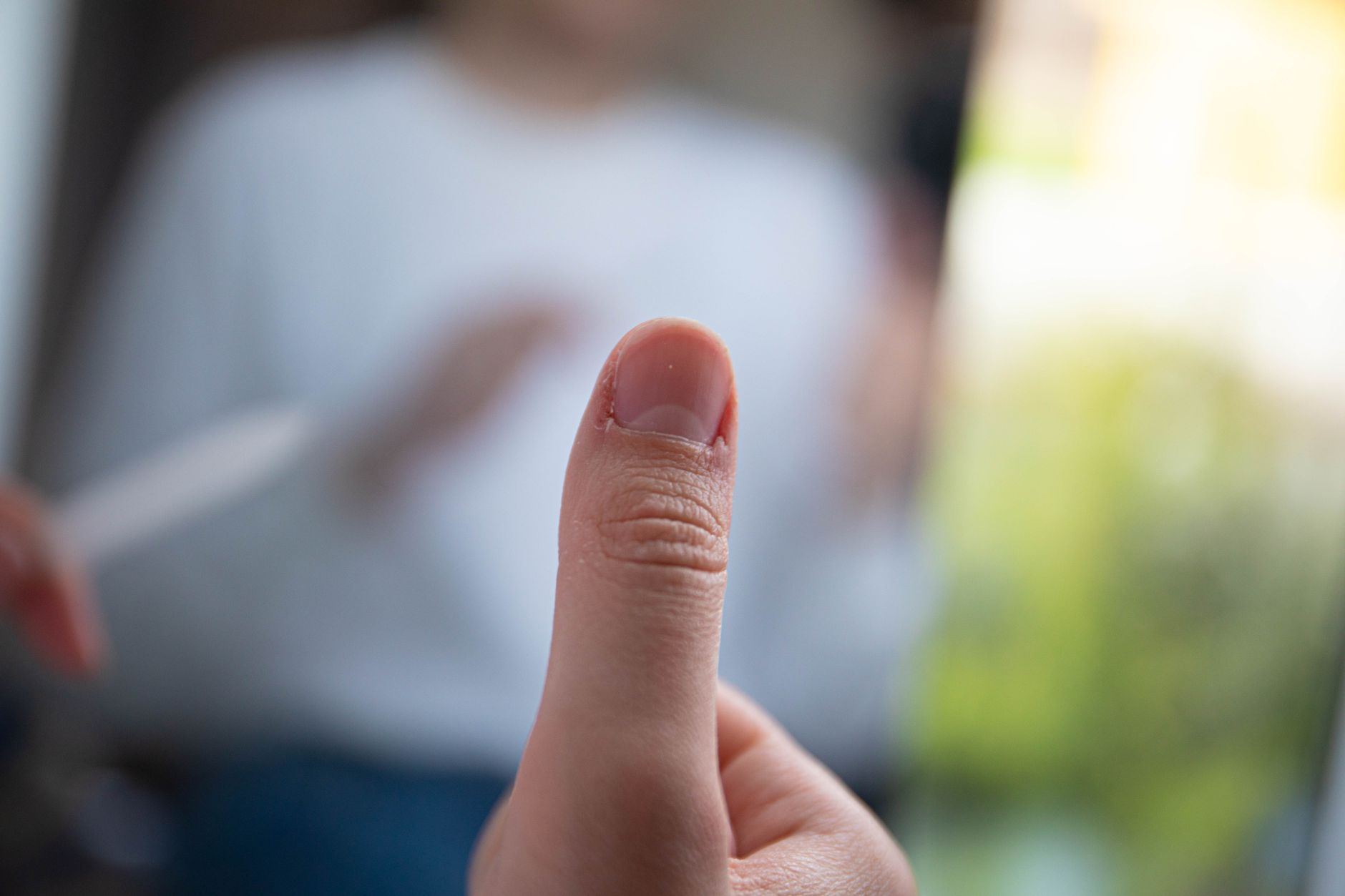 Close-up of a thumbnail against a blurred background