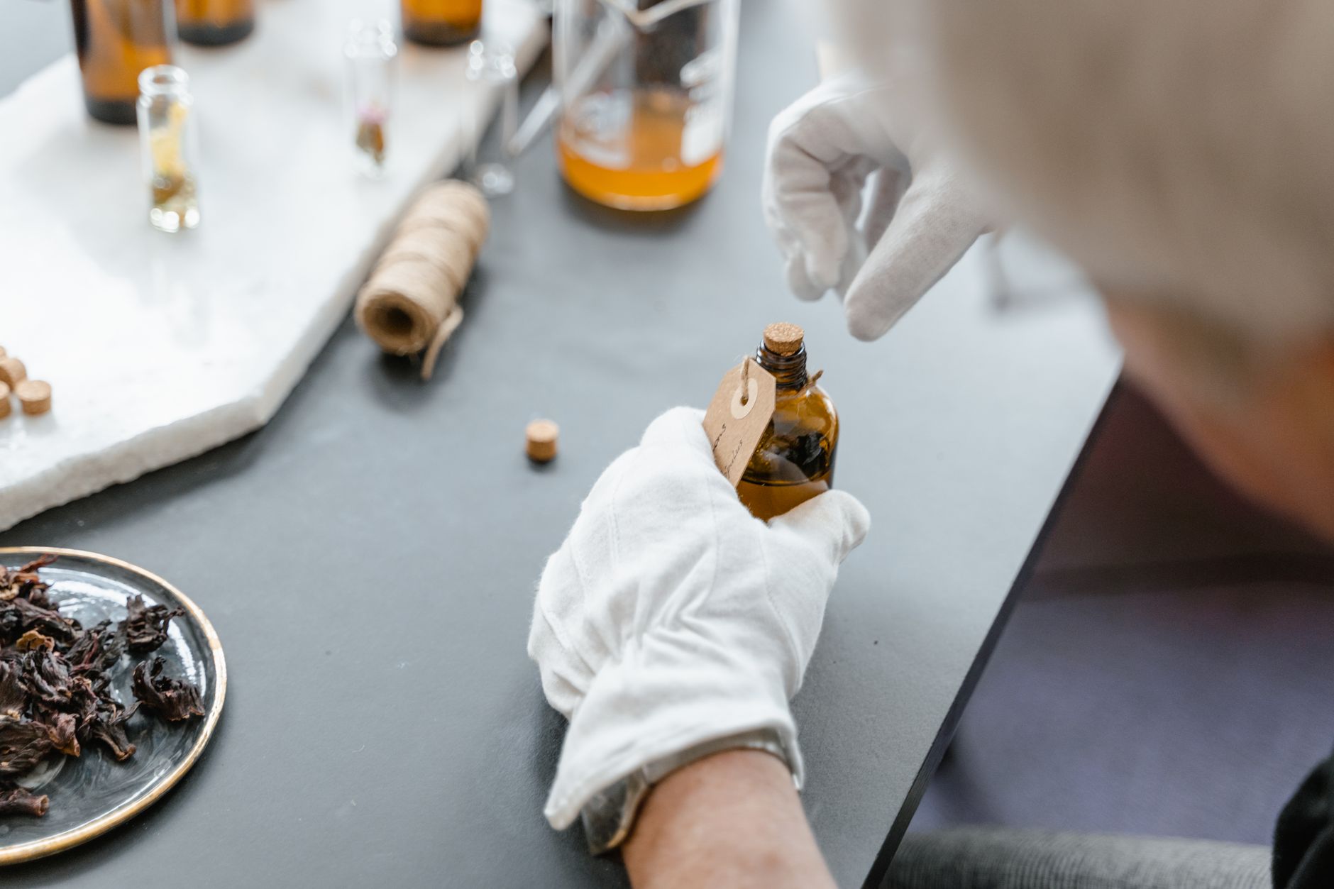 Beschriftung eines Extraktfläschchens mit Handschuhen im Labor