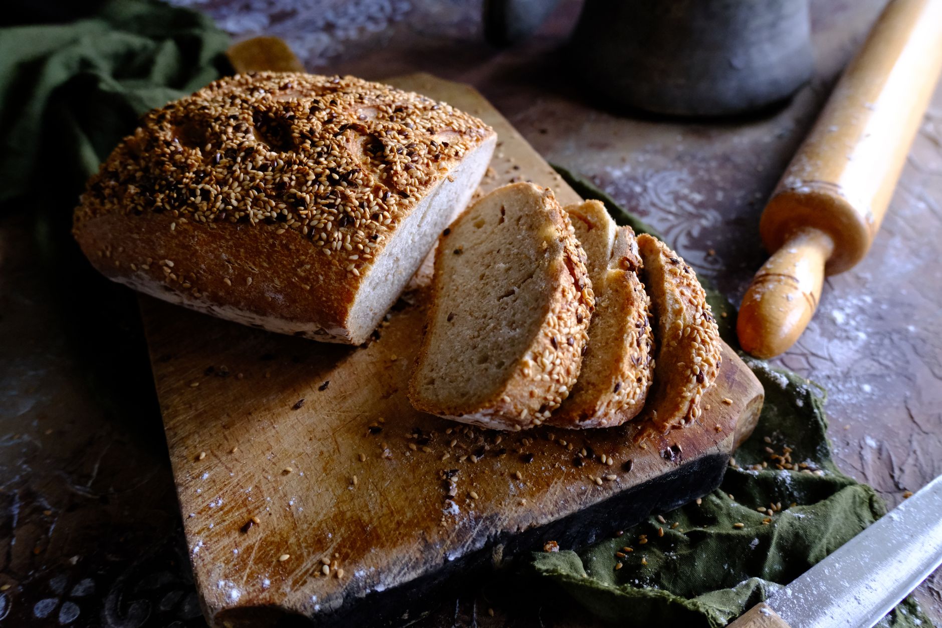 Angeschnittenes Vollkornbrot mit Saatenkruste auf einem Holzbrett